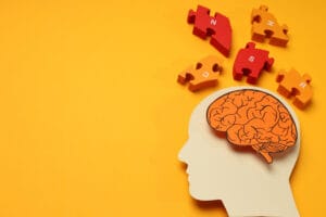 Ilustracja przedstawia sylwetkę głowy z mózgiem i puzzlami symbolizującą prewencję w chorobach neurologicznych.