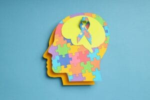 Grafika przedstawia profil głowy z kolorowych puzzli, symbolizująca prewencję w chorobach neurologicznych.